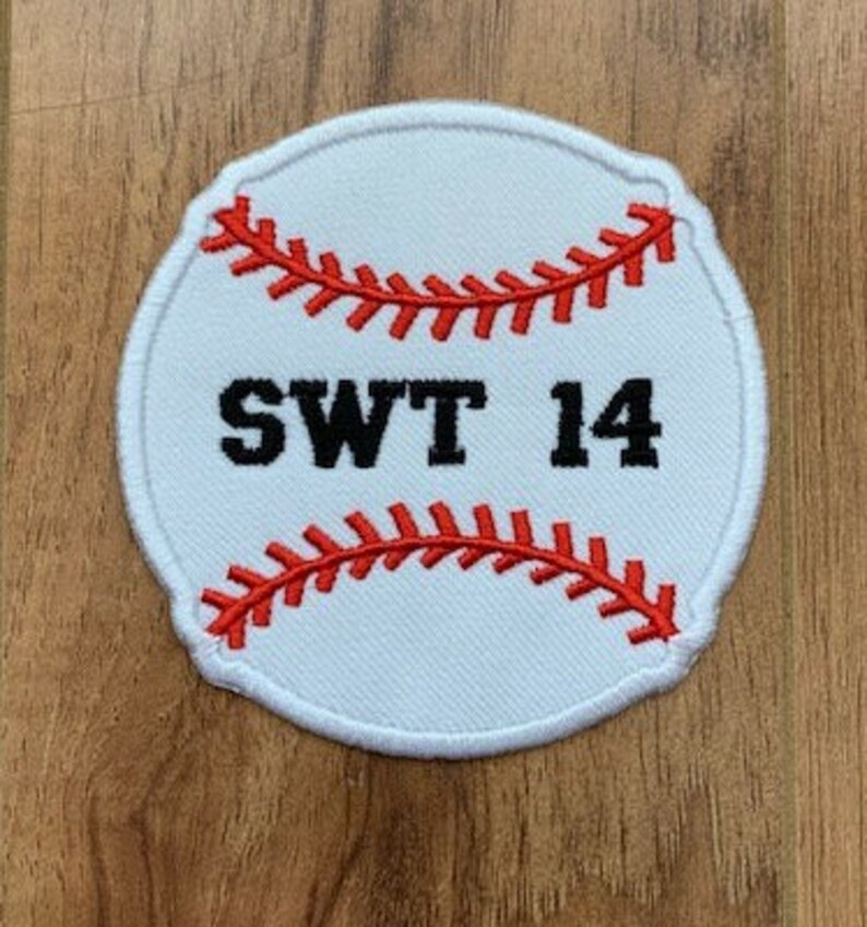 May include: White baseball-shaped patch with red stitching and the text "SWT 14" in black.