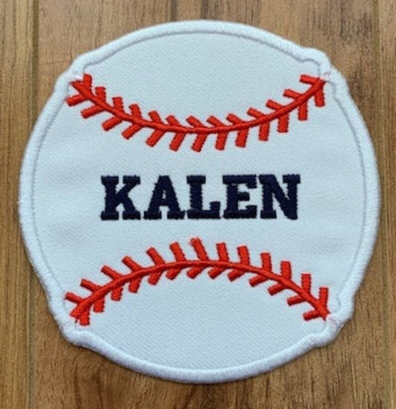 May include: White baseball-shaped patch with red stitching and the name "KALEN" in navy blue lettering.