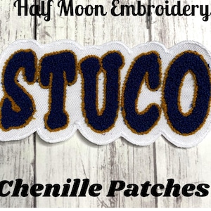 May include: A chenille patch with the word "STUCO" in navy blue letters with a gold outline, on a white background. The patch is in a wavy shape. The text "Half Moon Embroidery" and "Chenille Patches" are above and below the patch.