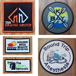 K&ouml;nnte beinhalten: Vier gestickte Patches mit verschiedenen Designs. Der erste Patch ist schwarz mit orangefarbenem Rand und zeigt ein wei&szlig;es Geb&auml;ude mit dem Text "The Gradiz Group". Der zweite Patch ist grau mit gelbem Hintergrund und zeigt zwei gekreuzte Paddel mit dem Text "Kay Bay". Der dritte Patch ist wei&szlig; mit blauem Rand und zeigt ein Haus mit dem Text "Golden Rule Realty" und einer Telefonnummer. Der vierte Patch ist wei&szlig; mit schwarzem Rand und zeigt eine Cartoon-Figur, die auf einem Flugzeug schl&auml;ft, mit dem Text "Round Trip Anesthesia".