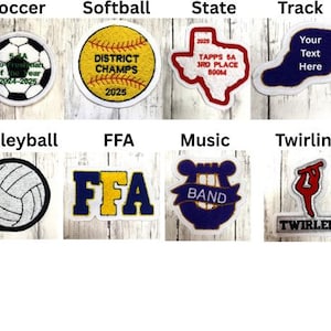 May include: A collection of embroidered patches featuring various sports and activities. Patches include soccer, softball, volleyball, track, FFA, music, and twirling. Each patch has a unique design and text, such as "District Champs" and "Your Text Here".