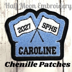 May include: Blue and black chenille patch with white flags that say "2027" and "SPHS" and the name "CAROLINE" in black lettering.