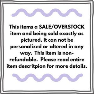 May include: A square sign with a dark gray border and light purple wavy lines at the top and bottom. The text reads: This items a SALE/OVERSTOCK item and being sold exactly as pictured. It can not be personalized or altered in any way.