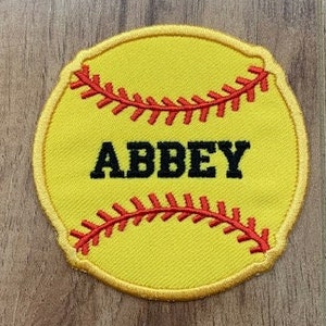 May include: Yellow softball patch with red stitching and black outline. The word "ABBEY" is embroidered in black on the patch.
