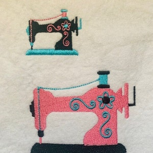 May include: Two embroidered sewing machines, one black with turquoise thread and the other pink with turquoise thread.