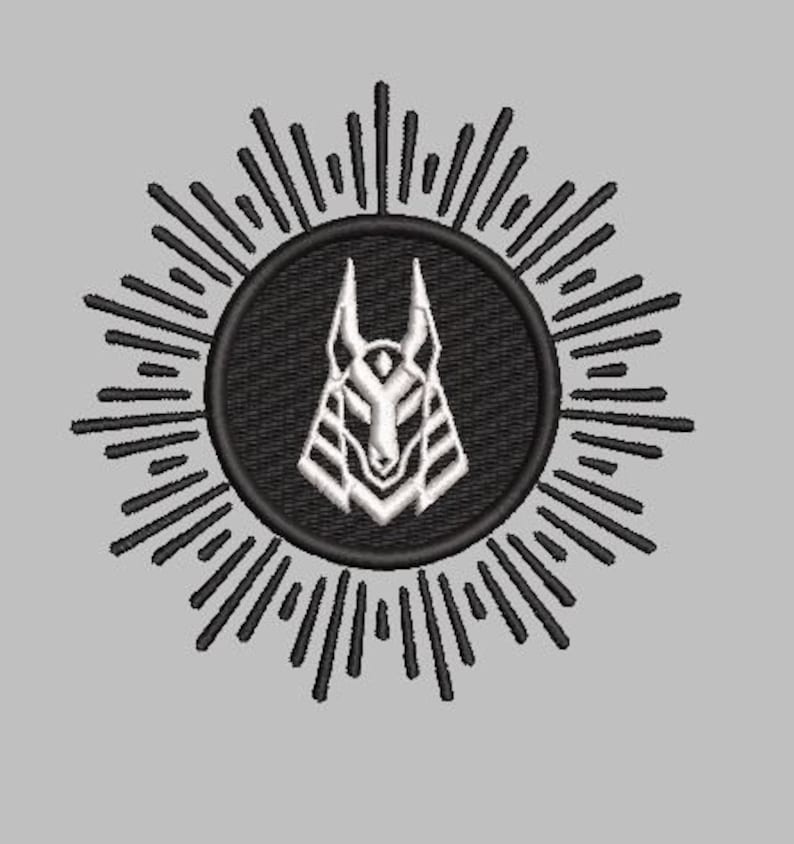 May include: Black and white stylized illustration of an anubis jackal head with a sunburst design around it.