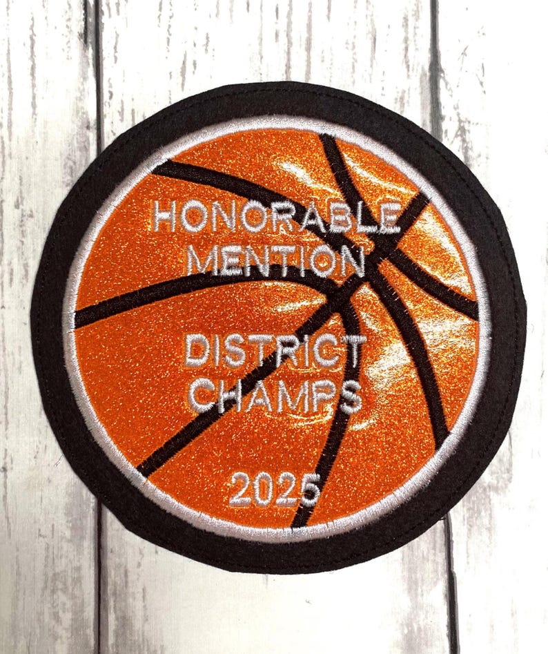 May include: Orange and black basketball patch with white text that reads "Honorable Mention District Champs 2025".
