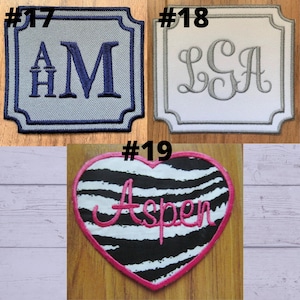 May include: Three embroidered patches. The first is light blue with dark blue letters "AM" and "AH". The second is white with gray letters "LSA". The third is a heart-shaped patch with zebra stripes and the name "Aspen".