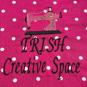 May include: Pink sewing machine with gold accents on a pink background with white polka dots. The text "TRISH Creative Space" is below the sewing machine.