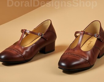 May include: A pair of brown leather Mary Jane shoes with a T-strap and buckle closure. The shoes have a rounded toe and a small block heel. The image includes the text "DoralDesignsShop".