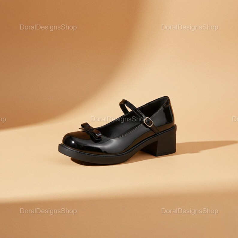 May include: Black patent leather Mary Jane style shoe with a bow detail on the toe. The shoe has a chunky heel and a strap that buckles across the top of the foot. The shoe is set against a neutral background.