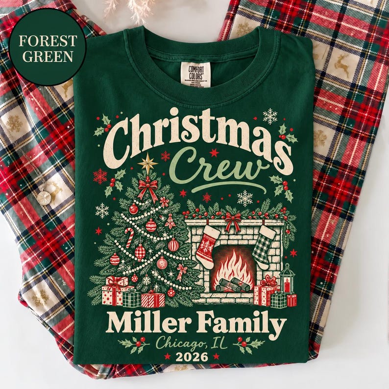 May include: A forest green t-shirt featuring a graphic of a Christmas tree, a fireplace with stockings, and wrapped gifts. The text reads Christmas Crew, Miller Family, Chicago, IL, and 2026. The design includes snowflakes, holly, and ornaments.