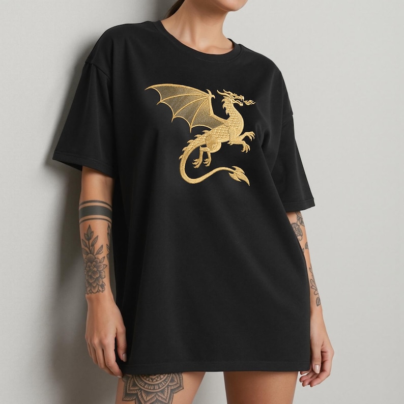 May include: Black t-shirt featuring a gold dragon design. The dragon is depicted with outstretched wings and a curved tail. The design is centered on the front of the shirt. The shirt has short sleeves and a relaxed fit.