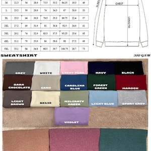 May include: Sweatshirt size chart with chest, length, sleeve, and shoulder measurements in inches and centimetres. Colour options include grey, white, light pink, navy, black, dark chocolate, sand, Carolina blue, and forest green.