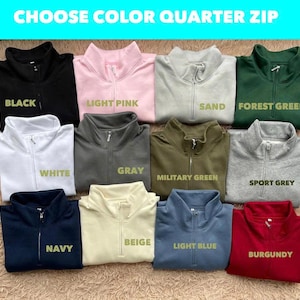 May include: A range of quarter-zip sweatshirts in colours such as black, light pink, sand, forest green, white, grey, military green, sport grey, beige, navy, light blue, and burgundy. The text "CHOOSE COLOR QUARTER ZIP" is at the top.