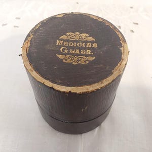 Vintage medicijndoos met meetglas