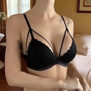 Puede incluir: Sujetador de encaje negro con tirantes delicados y borde festoneado. El sujetador presenta un diseño de tiras en el pecho y una sutil aros para soporte. Una elegante pieza de lencería.