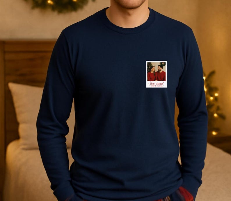 May include: Navy blue long-sleeve shirt with a small, rectangular photo print on the chest. The photo shows a couple in red sweaters. The text "Merry Christmas" and "Love & Family" is printed below the photo.