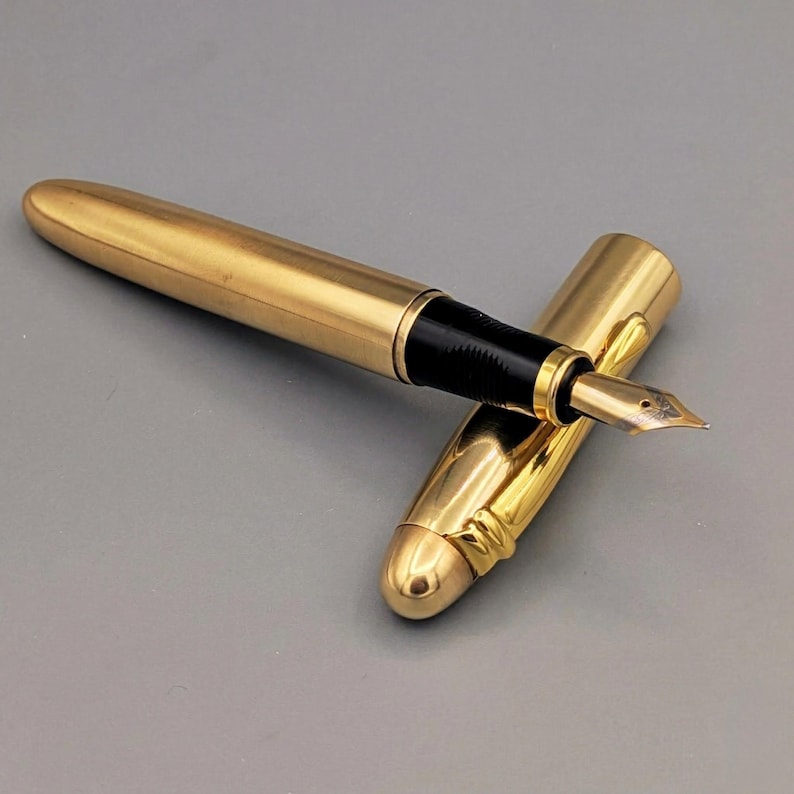 Luxury brass writing pen held in hand showing size and grip