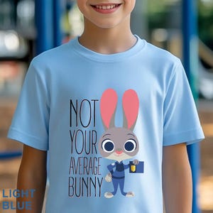 Puede incluir: Una taza de cer&aacute;mica blanca con asa negra y el texto "But First, Coffee" en negrita negra. La taza se encuentra sobre un fondo borroso, sugiriendo un ambiente acogedor.