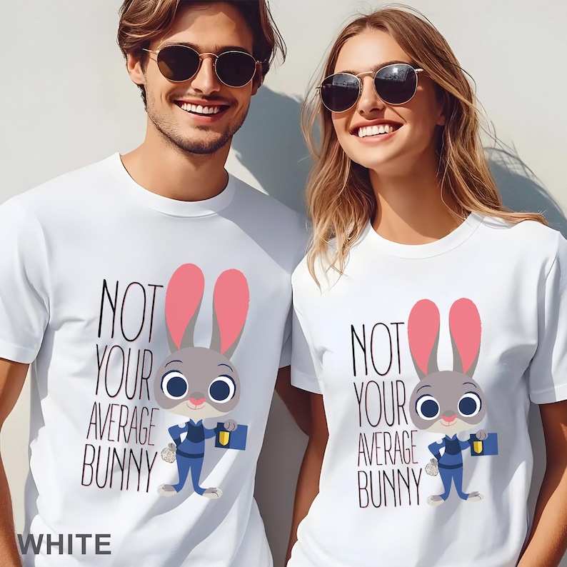 Puede incluir: Camisetas blancas con el texto "NOT YOUR AVERAGE BUNNY" y un personaje de conejo de dibujos animados. El conejo tiene pelo gris, orejas rosas y lleva un uniforme azul. La palabra "WHITE" est&aacute; abajo.