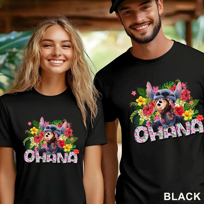 May include: Black t-shirts featuring a colorful graphic of a cartoon character surrounded by tropical flowers and the word "OHANA" in a pink and white font. The shirts are worn by two people.