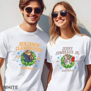 以下が含まれることがあります： 映画「ズートピア」のキャラクターが描かれた白いTシャツ。片方には「Benjamin Clawhauser」のイラスト、もう片方には「Jerry Jumbeaux Jr.」のイラスト。どちらも「Zootopia」と「2016」の文字が入っています。