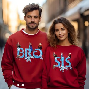 Op de afbeelding: Rode sweatshirts met de woorden "BRO" en "SIS" in blauw, met figuren uit een animatiefilm. Een bijpassende set, ideaal voor broers en zussen of koppels. Het woord "RED" staat onderaan.