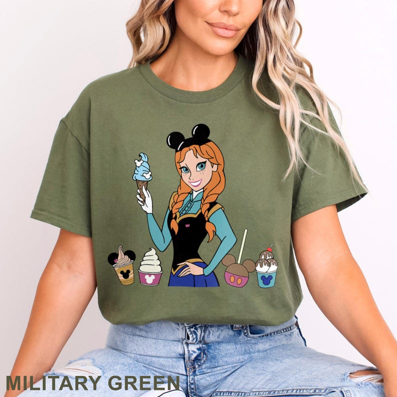May include: Military green t-shirt featuring a cartoon of a character with red hair and a black Minnie Mouse ear headband, holding an ice cream cone. The shirt also displays various ice cream treats. The text "MILITARY GREEN" is at the bottom.