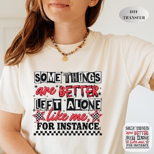 May include: Cream-colored t-shirt with the text "SOME THINGS are BETTER LEFT ALONE like me, FOR INSTANCE:" in a black and red design. The design includes star and checkered flag accents. DTF TRANSFER is printed on the top right.