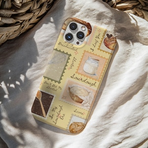 Może przedstawiać: Etui na telefon z motywem pieczywa. Etui zawiera ilustracje chleba, drewnianej łyżki i słoika z zakwasem. Tekst zawiera "Mighty Breaducated", "I Loaf You" i "In My Sourdough Era". Etui ma jasne żółte tło.