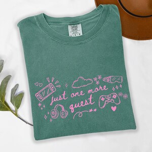 Light green cozy gamer shirt with pink graphic text just one more quest and cute gaming icons