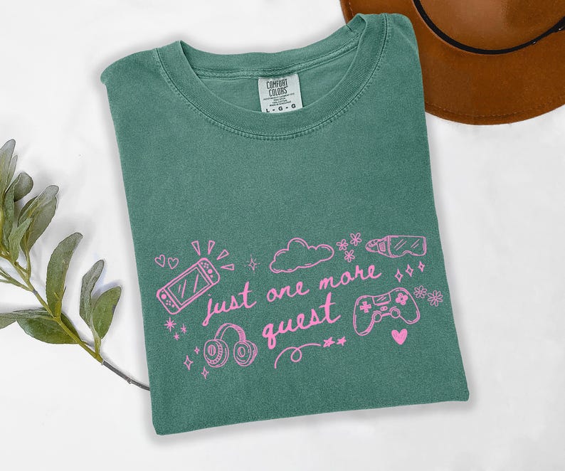 Light green cozy gamer shirt with pink graphic text just one more quest and cute gaming icons