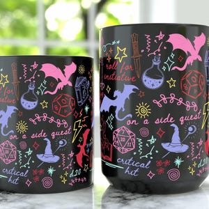 May include: Two black ceramic mugs with a fantasy-themed design. The mugs feature colorful illustrations of dragons, dice, potions, and text that reads "roll for initiative", "on a side quest", and "critical hit". The mugs have black handles.