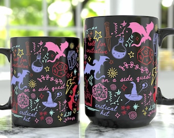 May include: Two black ceramic mugs featuring a colorful neon-style pattern of fantasy elements including dragons, d20 dice, wizard hats, potions, and daggers. The text reads roll for initiative, on a side quest, and critical hit in cursive script.