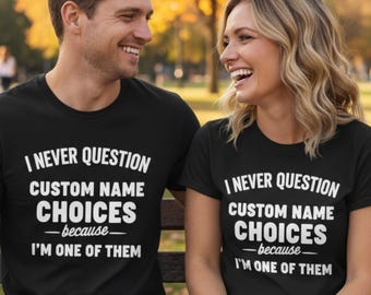 May include: Two people wearing matching black t-shirts with the text "I NEVER QUESTION CUSTOM NAME CHOICES -because- I'M ONE OF THEM" in white. The people are smiling and appear to be in a park setting.