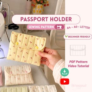 May include: A quilted passport holder sewing pattern featuring a light yellow fabric with a red cherry print and two yellow snap buttons. The digital file includes A4, A0, and letter formats, a beginner-friendly guide, and a video tutorial link.