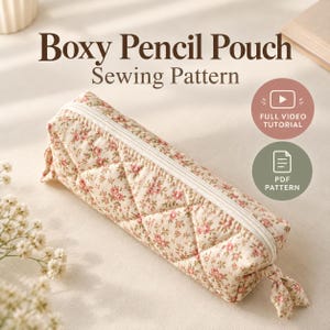 Peut inclure: Un patron de couture pour trousse à crayons rectangulaire en tissu matelassé avec un petit motif floral rose sur fond crème. La trousse possède une fermeture éclair blanche. Le texte indique Boxy Pencil Pouch Sewing Pattern, Full Video Tutorial, PDF Pattern.