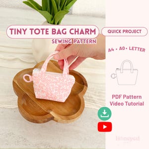 May include: A tiny tote bag charm sewing pattern featuring a pink and white floral fabric mini bag with a zipper and a small ring attachment. The image includes text: TINY TOTE BAG CHARM SEWING PATTERN, QUICK PROJECT, A4, A0, LETTER, PDF Pattern, Video Tutorial.