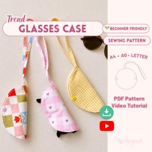 Puede incluir: Tres estuches para gafas de tela en forma de semicírculo con correas. Uno presenta un patrón de cuadros multicolor con una flor roja, otro es de cuadros vichy rosa y blanco con corazones pequeños, y otro es de cuadros vichy amarillo y blanco.