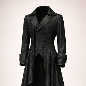 以下が含まれることがあります： ノッチカラー、ボタン付き袖口、ユニークな非対称裾が特徴の、仕立ての良い黒のロングコート。 コートは、フィットした胴体と流れるようなスカートを備え、劇的なシルエットを作り出しています。 この衣服は、暗い、おそらく革のような素材で作られています。