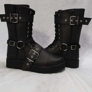 Black leather wrestling boots with lace-up front, side zipper, and buckle straps. Handmade wrestling shoes designed for professional wrestlers, cosplay, and stage performance. Durable sole for strong grip in the ring, crafted from premium leather for long-lasting comfort and stability. Perfect unisex wrestling footwear for men and women with custom sizing available. Stylish wrestling boots that combine performance, strength, and attitude for competition or cosplay use.