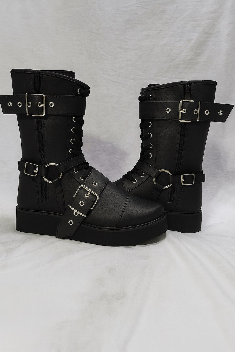 Black leather wrestling boots with lace-up front, side zipper, and buckle straps. Handmade wrestling shoes designed for professional wrestlers, cosplay, and stage performance. Durable sole for strong grip in the ring, crafted from premium leather for long-lasting comfort and stability. Perfect unisex wrestling footwear for men and women with custom sizing available. Stylish wrestling boots that combine performance, strength, and attitude for competition or cosplay use.