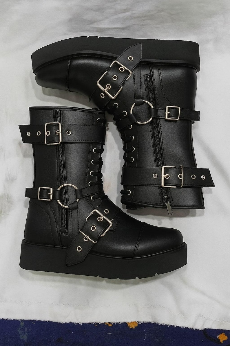 Pair of leather wrestling boots shown side by side, highlighting the bold buckle straps and strong leather build. Designed for professional wrestling matches and cosplay costumes, these unisex boots feature premium leather, durable soles, and lace-up closure for a snug fit. Ideal for stage performance and cosplay characters requiring wrestling gear. Handmade craftsmanship guarantees long-lasting wear and unique style for both men’s and women’s wrestling footwear collections.