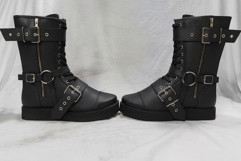 Close-up of handmade wrestling boots in black leather with detailed stitching, secure lace-up design, and adjustable buckle straps. These pro wrestling shoes are built for durability, comfort, and stability in the ring. Featuring side zippers for quick wear, they are ideal for professional wrestlers, cosplay performers, and collectors. Custom size options ensure a perfect fit for men and women. Durable leather construction makes them reliable for wrestling, stage, or costume use