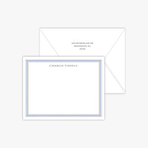 May include: White stationery set featuring a blank notecard with a blue Greek key border and the name "Charlie Tisdell" printed in the center. An envelope with the address "2439 Wyoming Ave NW, Washington, DC 20008" is in the background.