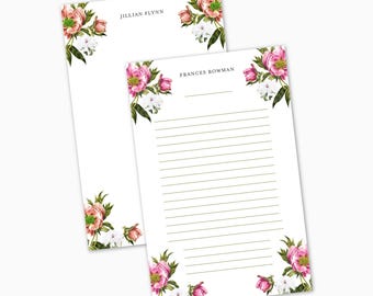 May include: Two white notepads with floral corner designs. One notepad has the name "JILLIAN FLYNN" at the top. The other notepad has the name "FRANCES BOWMAN" and lined paper. The floral design features pink and white flowers with green leaves.