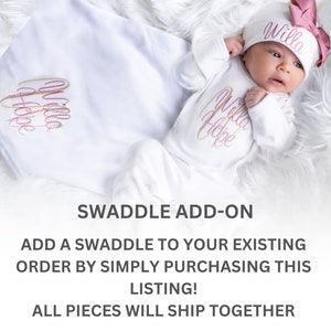 May include: White swaddle blanket with pink and gold embroidery that says "Willa Hope".