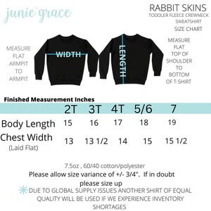 May include: Black toddler fleece crewneck sweatshirt size chart. Measurements include body length from 15 to 19 inches and chest width from 13 to 15 1/2 inches. The chart also shows the measurements for sizes 2T, 3T, 4T, 5/6, and 7.