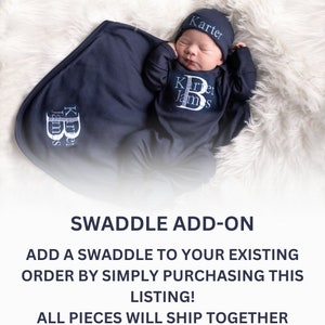 May include: A navy blue swaddle blanket with the name "Karter James" embroidered on it. A baby wearing a navy blue onesie with the same name embroidered on it and a matching navy blue hat with the name "Karter" embroidered on it.